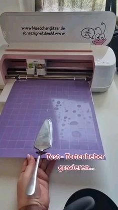 a person is using a machine to cut paper with a large spatula on it