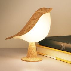 a wooden bird lamp sitting on top of a book