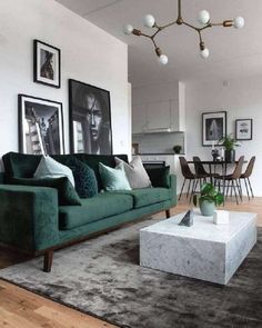 a living room filled with furniture and pictures hanging on the wall above a coffee table