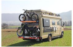 a motor home with a bike on the roof and two bikes mounted to it's back