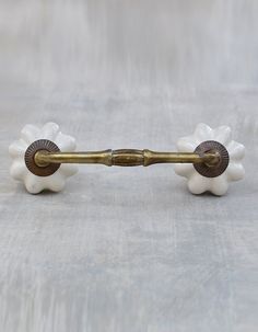 an antique brass and white flower shaped handle