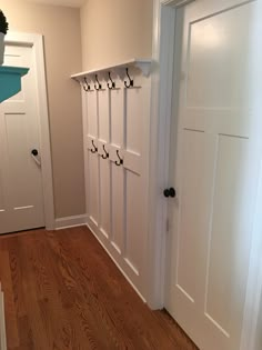 an empty room with white doors and hooks on the door knobs that are attached to the wall