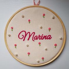 a embroidery kit with the word marina written in red and pink flowers on it's side