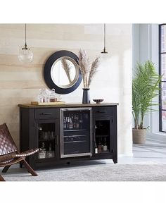 a room with a chair, table and a wine cooler in front of a mirror