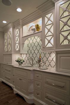 an elegant kitchen with white cabinets and marble counter tops is pictured in this image from the front view