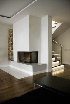 an empty living room with a fireplace and stairs