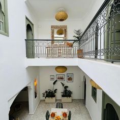 an indoor dining area with table, chairs and potted plants on the balcony railing