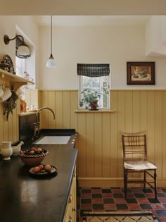 a bowl of fruit is sitting on the counter in this country kitchen with wood paneling