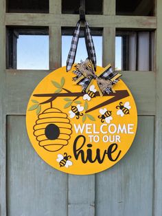 a sign that says welcome to our hive hanging on a door with the words'welcome to our hive'painted on it