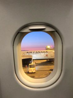 an air canada airplane window with the reflection of another plane in it