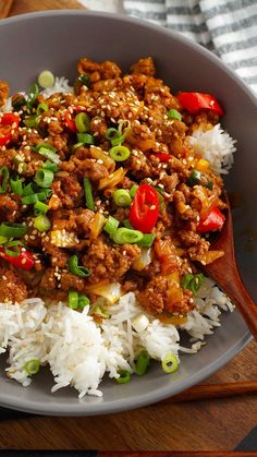 a close up of a plate of food with rice and meat on it next to chopsticks