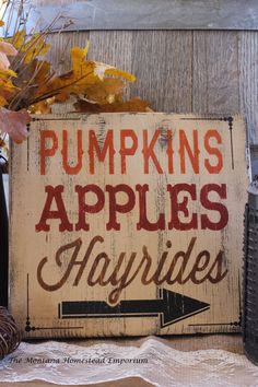 a wooden sign that says pumpkins apples and hayrises on top of a table