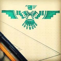 a pen and pencil sitting on top of a piece of paper with an eagle drawn on it