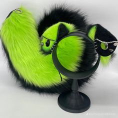 a green and black furry object sitting on top of a table