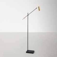 a black and gold floor lamp on a white surface