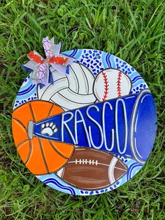 a ceramic plate with sports items on it sitting in the grass