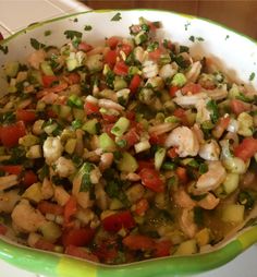 a bowl filled with shrimp and veggies on top of a table