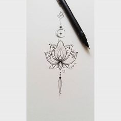 a drawing of a lotus flower on paper next to a pen and ink dropper