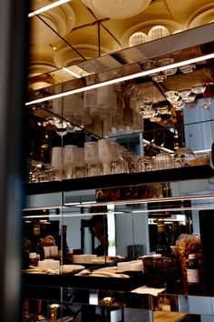 a kitchen filled with lots of glassware and plates on top of a metal counter