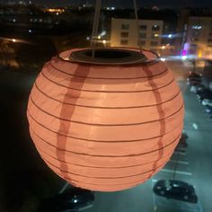 a large lantern hanging from the side of a building in front of a parking lot