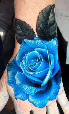 a person's hand with a blue rose painted on it