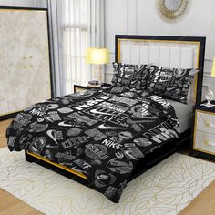 a bed with black and white designs on it in a room next to two lamps