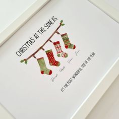 a christmas card with stockings hanging from a line