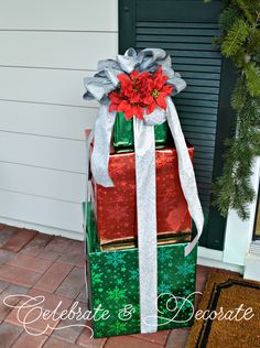 three wrapped presents sitting on top of each other in front of a christmas wreath and door