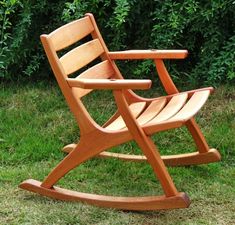 a wooden rocking chair sitting in the grass