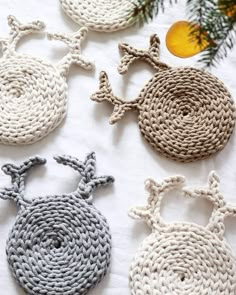 crocheted ornaments are laid out on a white sheet with pine branches in the background