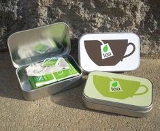 three tins with tea in them sitting on the ground