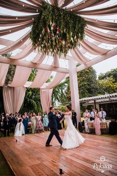 a bride and groom are dancing under the chute