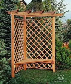 a wooden trellis in the middle of a yard with trees and bushes around it