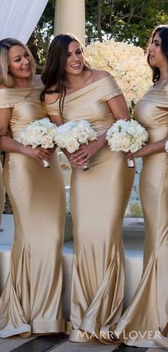 the bridesmaids are all dressed in gold gowns and holding their bouquets