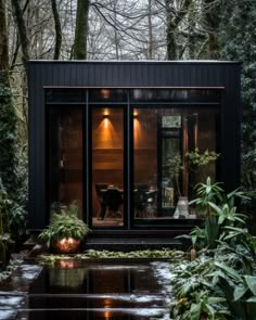 a small cabin in the middle of a forest with trees and plants on either side