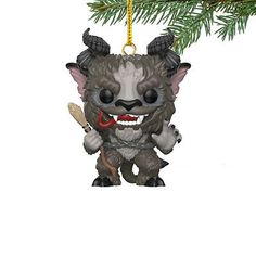 a christmas ornament hanging from a tree with an evil looking creature on it