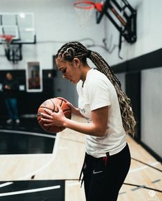 a woman holding a basketball in her right hand