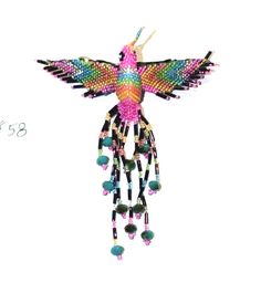 a colorful bird hanging from the side of a white wall with beads on it's wings