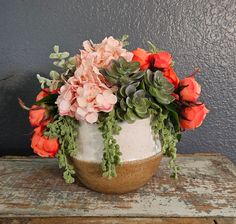 a white vase filled with flowers on top of a wooden table