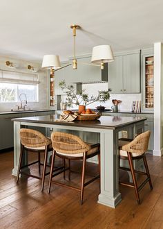 a kitchen island with two chairs in it