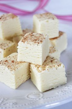 four pieces of white chocolate with cinnamon sprinkles on top, sitting on a plate