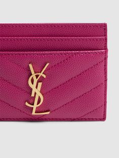 a pink card case with a gold saint laurent logo on the front and bottom corner