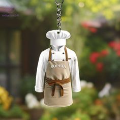 a small apron shaped like a chef's hat hanging from a chain