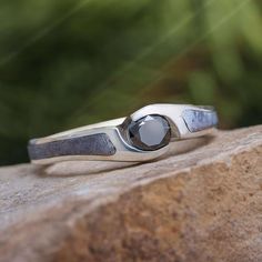 a silver ring sitting on top of a rock