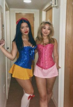 two women dressed in costumes standing next to each other