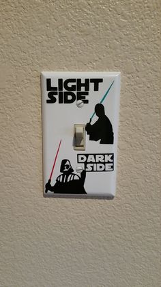 a light switch that has a darth vader sticker on it with the words, light side