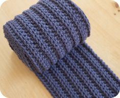 a knitted tie sitting on top of a wooden table