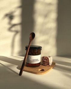 a wooden spoon sitting on top of a table next to a jar of honey