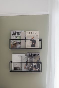 two black shelves with magazines on them in a bedroom