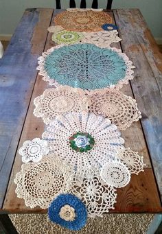 the table is made out of wood and has crocheted doily on it